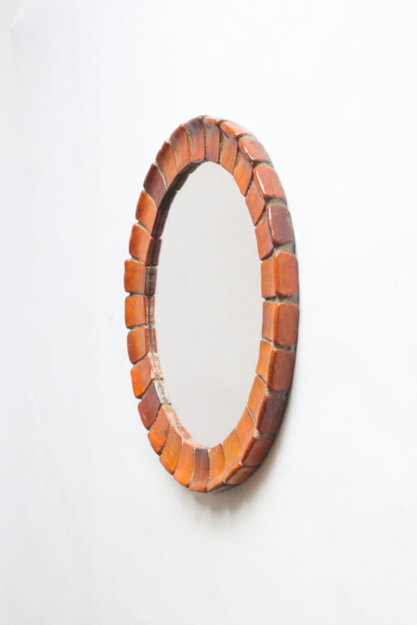 A mid century modern sixties round wall hanging mirror with a bevel consisting of small orange ceramic tiles | Century Soup |
