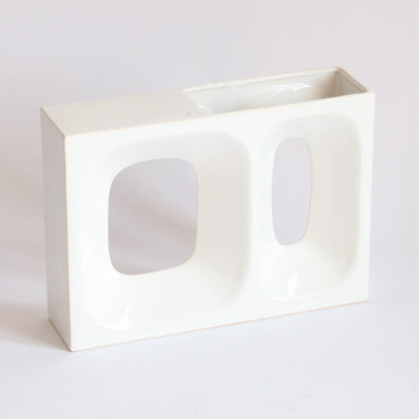 A square white porcelain vase with two cutout holes on the front, one smaller and one larger | Century Soup |