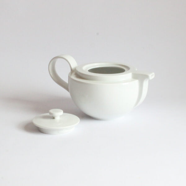 White porcelain teapot with a ledge near te top, the spout looks like the bow of a boat and follows down. The bottom half is rounded. Cult teapot by Dieter Sieger for Arzberg.