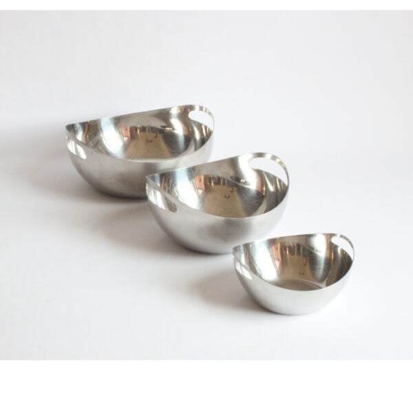 A set of three stacking round organic shaped stainless steel bowls, the sides protrude upwards and make room for the handles holes