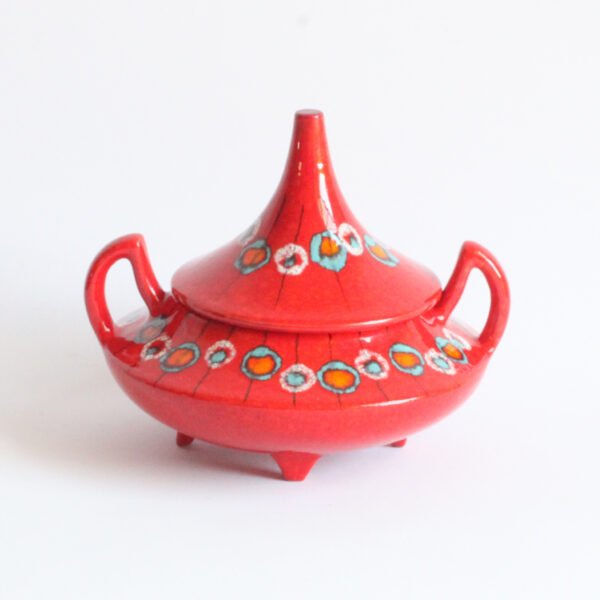Red ceramic bonbonnière or biscuit box with a pointy "hat shaped" lid and devil horn shaped handles. Front view 2.