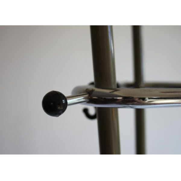 Three tall bent steel tubes with a chrome triangle top that holds the hooks. Tubular coat rack by Tubax