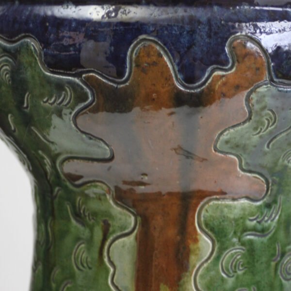 A large flemish earthenware pedestal jardiniere by laigneil, kortijk belgium 1900s. Influences of art nouveau, folk art, arts & crafts, naturalism. Executed in flemish earthenware decorated with a sgraffito technique, shades blue brown and green glazing. Very natural colors. On the cache-pot a scene of farmers and nuns, and trees all around. The pedestal decorated with tall trees and castles, a river below and layers of sky / clouds / forest | Century Soup |