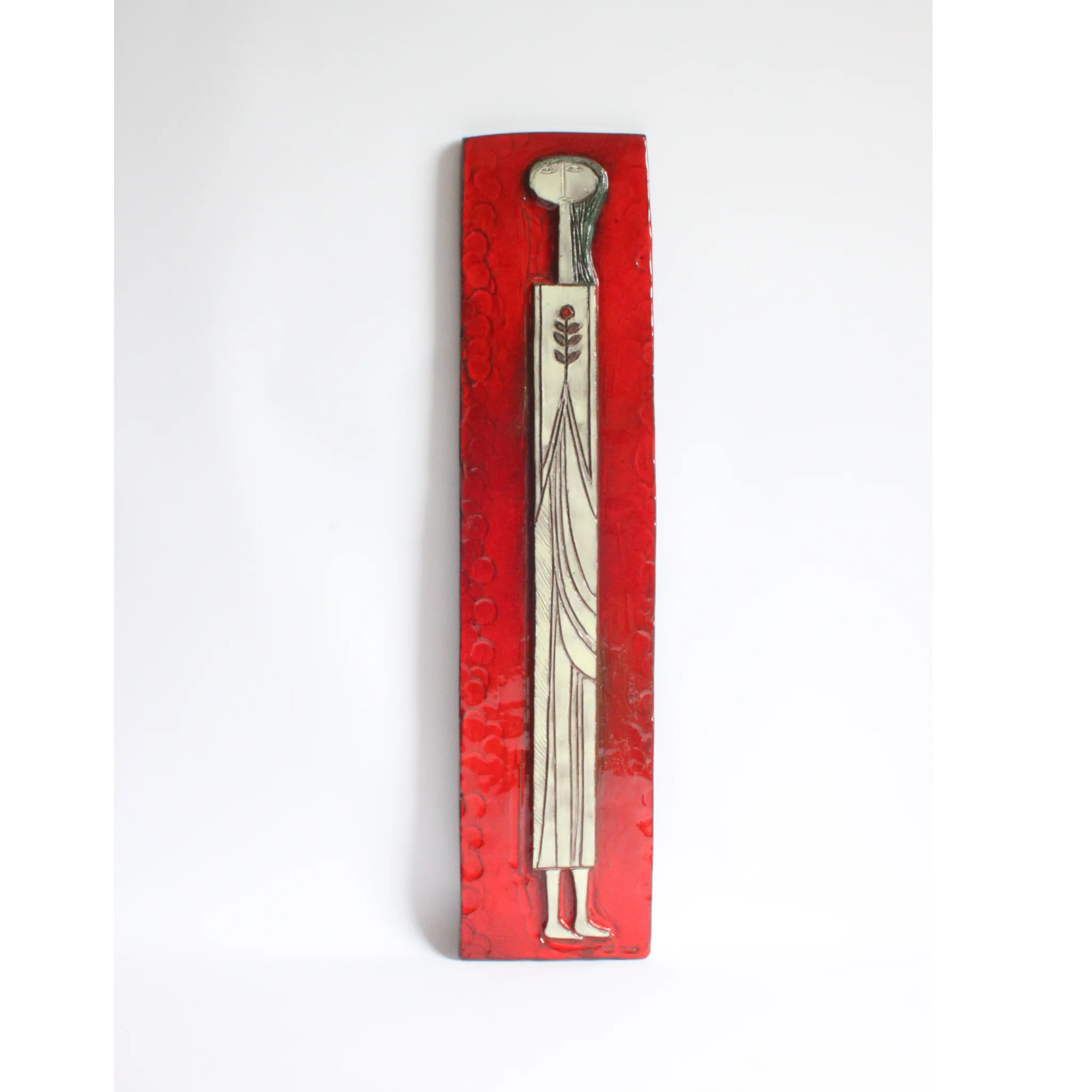 Tall square ceramic wall ornament with a red glaze by Oswald Tieberghien. Depicting a stylized elongated woman in a white dress holding a flower.