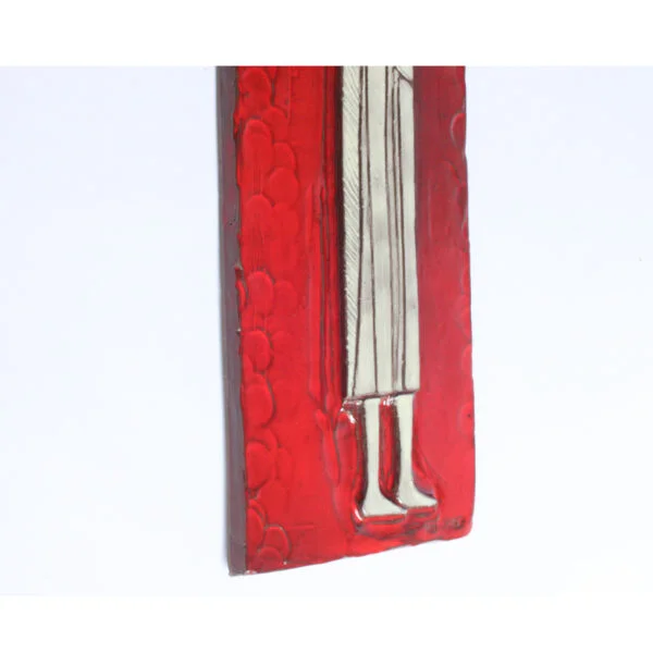 Tall square ceramic wall ornament with a red glaze by Oswald Tieberghien. Depicting a stylized elongated woman in a white dress holding a flower.