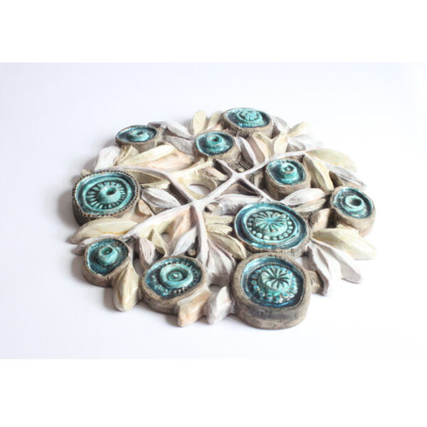 Flat ceramic bouquet of flowers, consisting of white stems connecting to green abstracted medallion like flowers. A ceramic bas-reliëf wall ornament with flowers by Elisabeth Vandeweghe for Perignem Belgium.