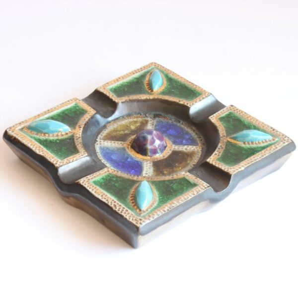 Vintage art deco square stoneware ashtray in gres de guerin with blue gemstones in the corners crackle glass inlays in blue, green and yellow. In the middle sits a large purple ceramic "gemstone". Very medieval magical forest fairy tale vibes. Century Soup vintage design.