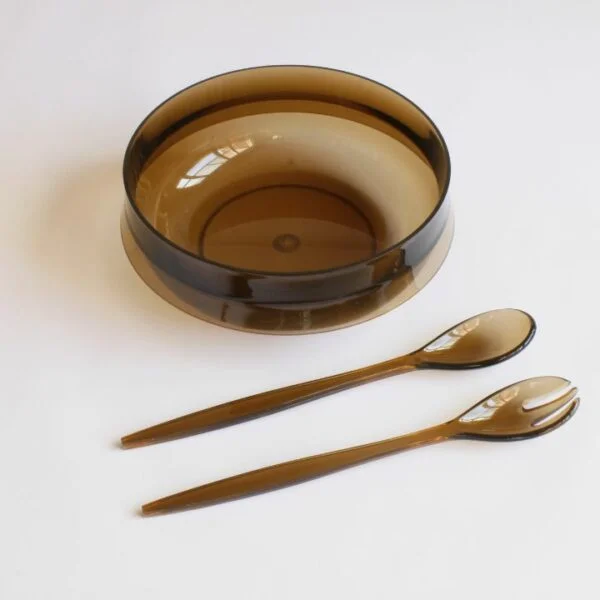 Guzzini per alimenti salad bowl, salad spoon and fork, and a pitcher in smoked lucite or acryl. A salad bowl or serving bowl with a very 1970s space age style rim (like Darth Vaders helmet), with a matching set of serving utensils. The pitcher had an opening in the lid so that the spoon can be used as a stirring tool. Both with the original Guzzini label, one with an additional label of the Belgium based design store that sold Italian design in the seventies | Century Soup |