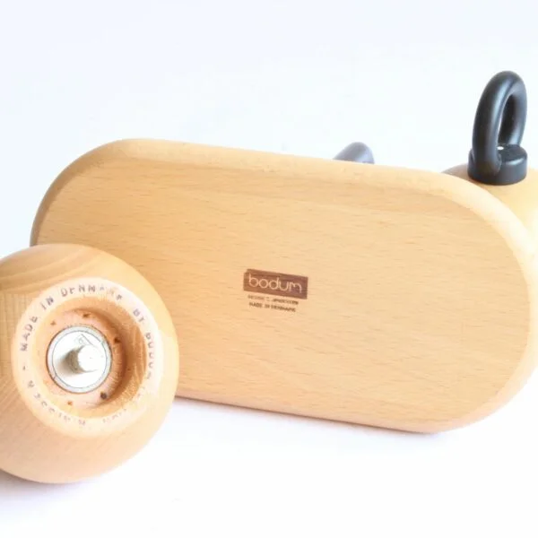 A set of pepper and salt mills / grinders designed by Richard Nissen & Carsten Jørgensen for Bodum, Denmark. The round beech wooden bodies with and castiron O-ring shaped handles. A beech wooden tray with a castiron handle serves as the base of the vintage condiment set | Century Soup |