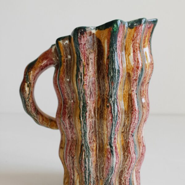 A set of six crazy colorful mugs and a pitchers in Vallauris ceramics, 1960s-1970s. Naturalistic shape where body resembles tree bark, and the handle swings back like a branch. The inside rim resembles a shell.