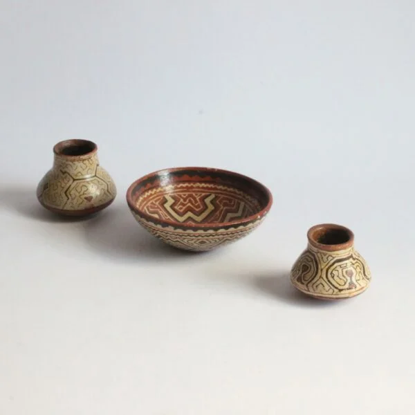 A set of three Shipibo earthenware vessels with intricate geometrical patterns. Almost resembling electronic circuit boards. One bowl and two jars or pots. The Shipibo of the Ucayali River, a southern tributary of the Upper Amazone in Peru, produce some of the finest polychrome prefire slip-painted earthenware pottery in the world. Also notable is that they are one of the few indigenous groups in which the primary artists are women. The Shipibo see and hear these geometric patterns in nature and reproduce the designs on their clothing, face paint, etc... Every design carries its own specific meaning. Century soup vintage design antiques curiosa collectibles antwerp.