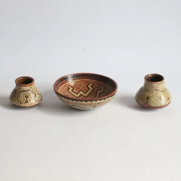 A set of three Shipibo earthenware vessels with intricate geometrical patterns. Almost resembling electronic circuit boards. One bowl and two jars or pots. The Shipibo of the Ucayali River, a southern tributary of the Upper Amazone in Peru, produce some of the finest polychrome prefire slip-painted earthenware pottery in the world. Also notable is that they are one of the few indigenous groups in which the primary artists are women. The Shipibo see and hear these geometric patterns in nature and reproduce the designs on their clothing, face paint, etc... Every design carries its own specific meaning. Century soup vintage design antiques curiosa collectibles antwerp.