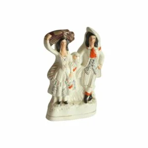 A Staffordshire earthenware figurine sculpture of a Scottish Couple, 19th Century. Both victorian attire, the man wears a hat sidewas and the woman in carrying a bale of clothes? on her head. Decorated with green, blue and brown dots. With red details for the scarf and shoes. Century soup vintage design antiques curiosa collectibles antwerp.