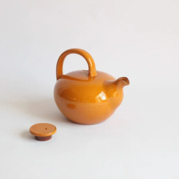 A vintage artisanal Scandinavian modern style pottery teapot in a beige color. Rounded body with a large handle and the lid on the left side. The Ildfast collection was produced from 1941 till the 1960s. Marked underneat: BS for Brack and Sønner Denmark Century soup vintage design antiques curiosa collectibles antwerp.