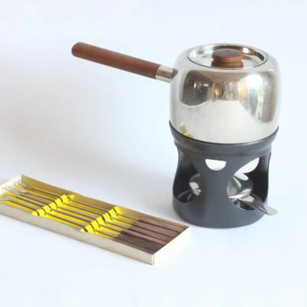 A fondue set by Timo Sarpaneva for Opa Oy, Helsinki. Designed in 1970. The Opa series is part of the collection of the Philadelphia museum of art aswell as the Helsinki design museum. Comes with a set of fondue forks in teak wood. Century soup vintage design antiques curiosa collectibles antwerp.