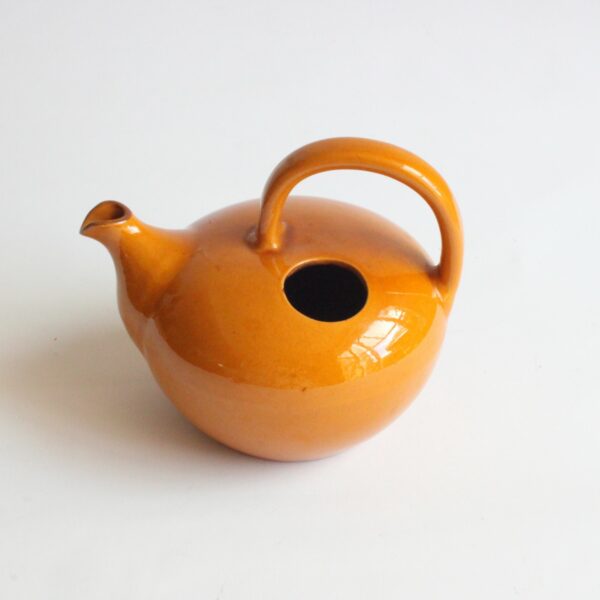 A vintage artisanal Scandinavian modern style pottery teapot in a beige color. Rounded body with a large handle and the lid on the left side. The Ildfast collection was produced from 1941 till the 1960s. Marked underneat: BS for Brack and Sønner Denmark Century soup vintage design antiques curiosa collectibles antwerp.