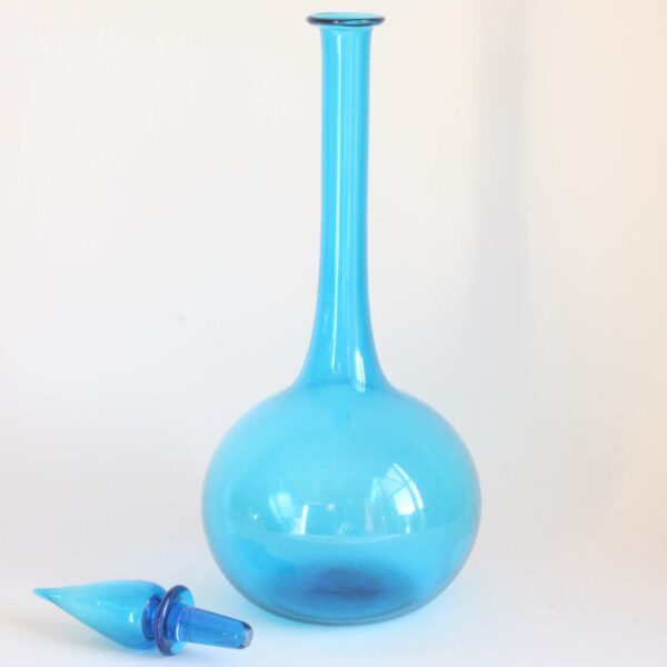 A vintage sky blue "genie" bottle with stopper in transparent handblown glass from the empoli region, tuscany Italy 1960s. Condition report: Excellent condition Label underneath: Mathot Vanhoffelen, a famous Antwerp based design store well known for importing Italian glass, ceramics and design pieces. Century soup vintage design antiques curiosa collectibles antwerp.