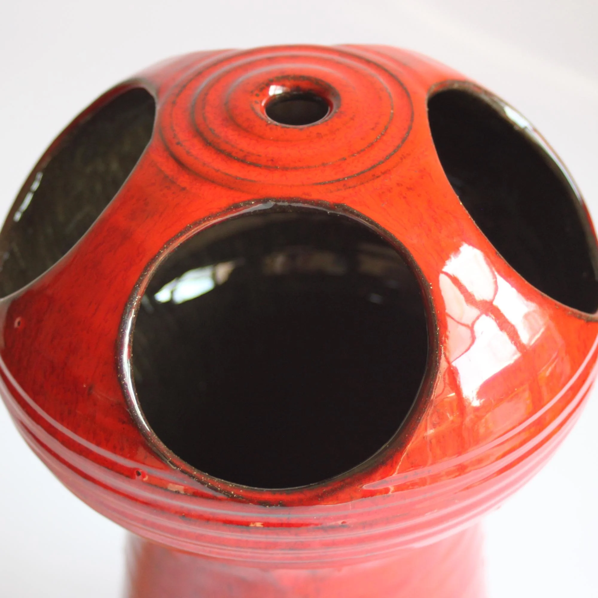 Red glazed space age style ceramic vase. Hand turned ribbed vase, round UFO-like head with four holes cutout. By Emiel Laskaris, Belgium 1960s. Emmanuel "Emiel" Laskaris was a Greek ceramic artist. He settled in Sint Niklaas and was active between the 1960s-1980s. Simultaneous with the Perignem,Amphora and Marechal ateliers. Century soup vintage design antiques curiosa collectibles antwerp.