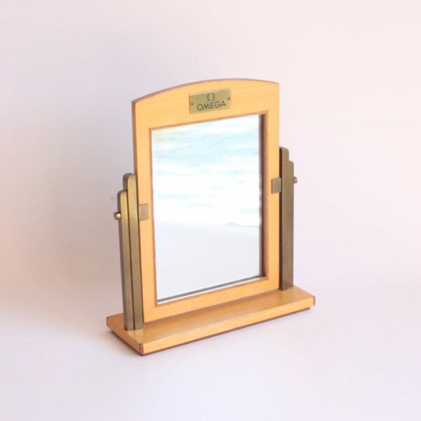 Art deco style dealers boutique mirror to try on Omega watches in the store. Made in Switzerland 1940s. Base and frame in marquetry with two kinds of wood. And two brass art deco shaped arms to hold the swiveling mirror. Century soup vintage design antiques curiosa collectibles antwerp.