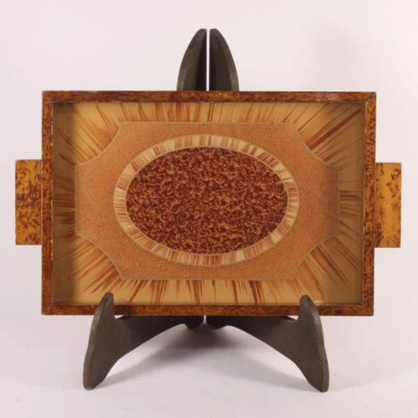 Art deco rectangular tray with an eglomisé painted glass surface and a painted wooden frame. The wood is painted with faux-bois patterns to resemble burlwood or root wood. Glass painted on underneath in typical art deco fashion, marquetry patterns in the middle and sunrays behind. Century soup vintage design antiques curiosa collectibles antwerp.