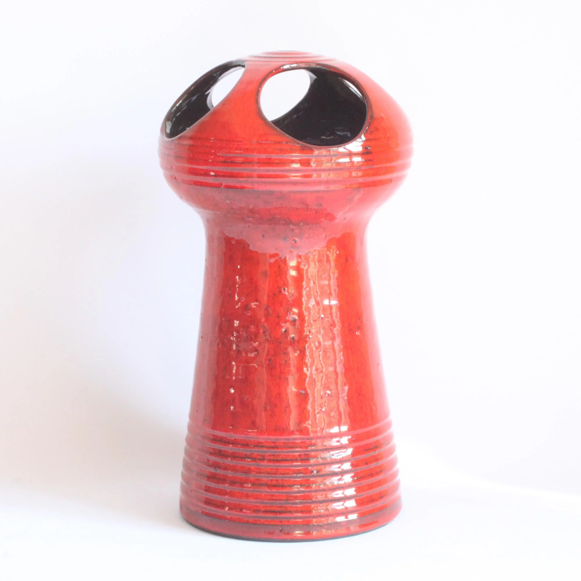 Red glazed space age style ceramic vase. Hand turned ribbed vase, round UFO-like head with four holes cutout. By Emiel Laskaris, Belgium 1960s. Emmanuel "Emiel" Laskaris was a Greek ceramic artist. He settled in Sint Niklaas and was active between the 1960s-1980s. Simultaneous with the Perignem,Amphora and Marechal ateliers. Century soup vintage design antiques curiosa collectibles antwerp.