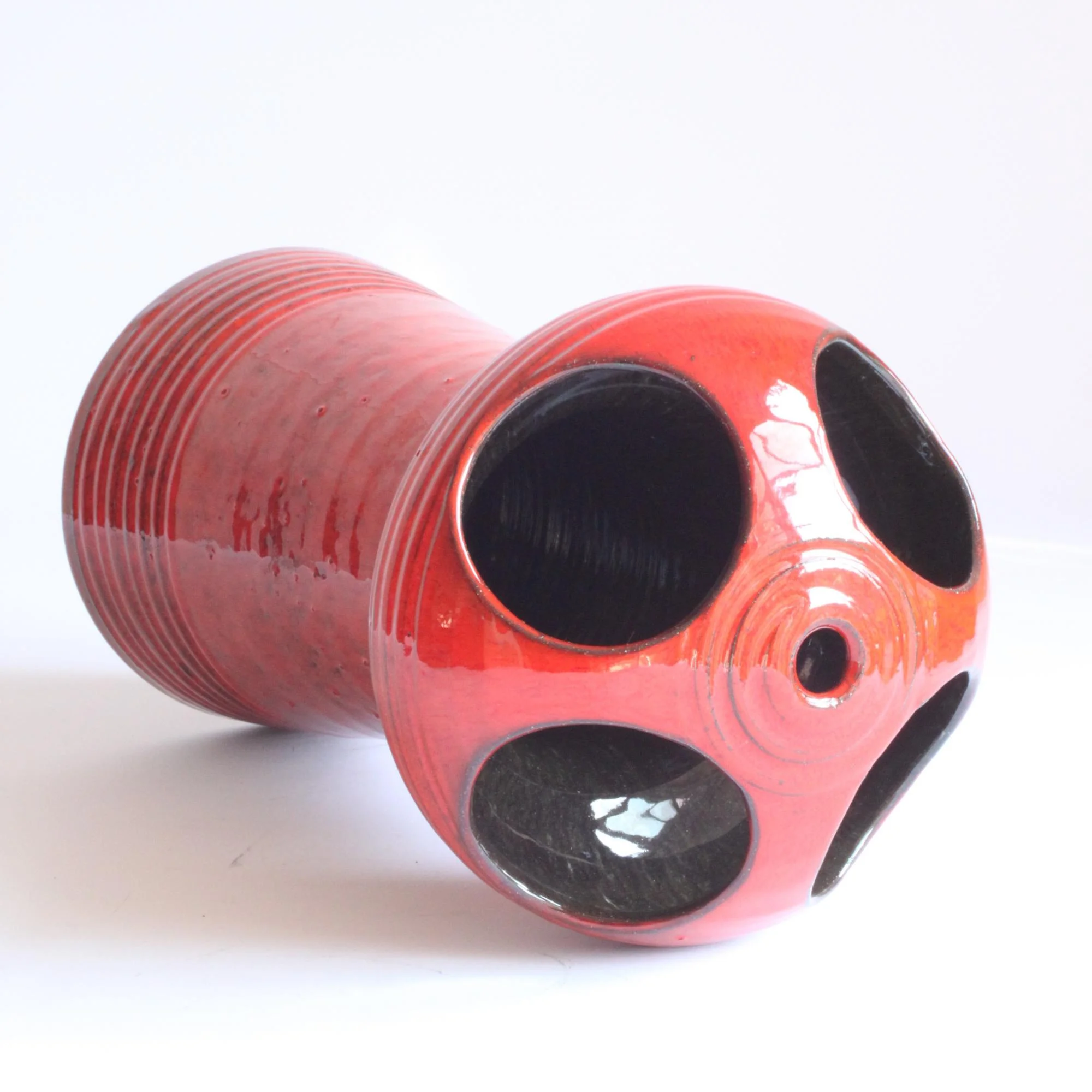 Red glazed space age style ceramic vase. Hand turned ribbed vase, round UFO-like head with four holes cutout. By Emiel Laskaris, Belgium 1960s. Emmanuel "Emiel" Laskaris was a Greek ceramic artist. He settled in Sint Niklaas and was active between the 1960s-1980s. Simultaneous with the Perignem,Amphora and Marechal ateliers. Century soup vintage design antiques curiosa collectibles antwerp.