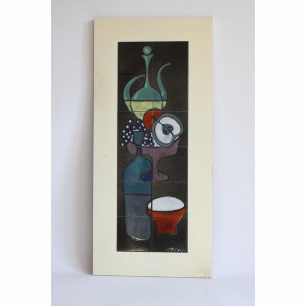 A tall ceramic tile tableau or wall plaque by Capra Italy, 1960s. Depicting an abstract still-life. Modernistic composition of fruits, bottle, teapot, etc... in purple, green, yellow, blue, red and white glazing. On a charcoal black background. Condition report: Excellent vintage condition, may show minimal signs of wear consistent with age and use. Signed on bottom right corner tile: Capra